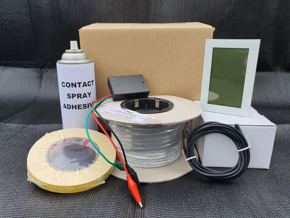 Photo of a floor heating kit with glue, heating elements, thermostat, and accessories